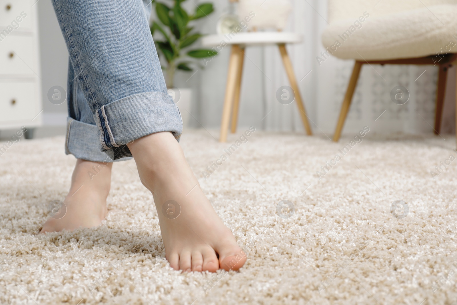 Photo of Woman standing on soft carpet at home, closeup. Space for text