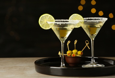 Photo of Glasses of Lime Drop Martini cocktail on grey table against blurred background