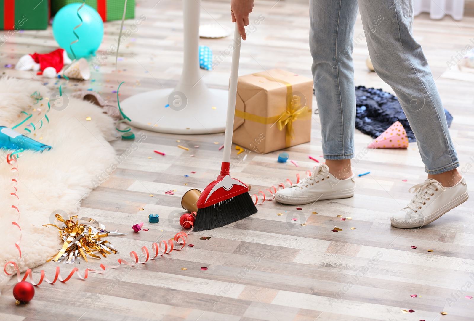 Photo of Woman sweeping messy floor after party, closeup