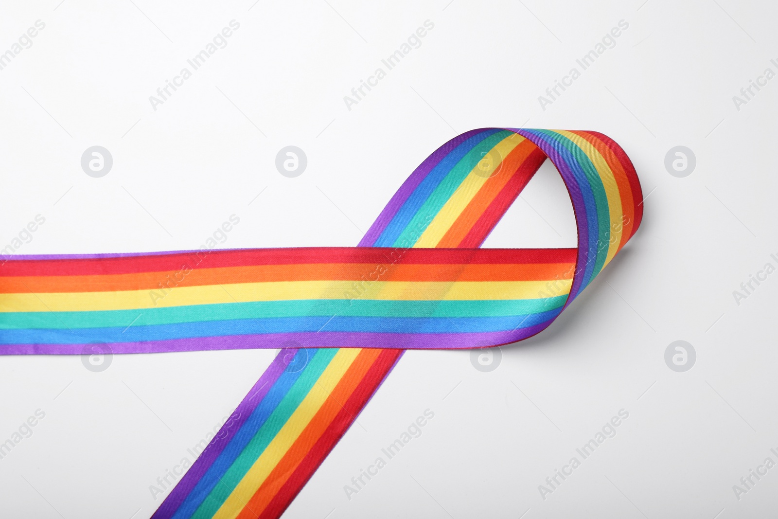 Photo of Rainbow ribbon on white background, top view. LGBT pride