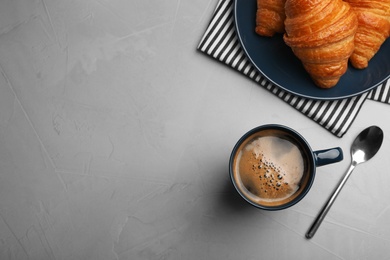 Photo of Flat lay composition with coffee and croissants on grey table, space for text