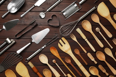 Set of modern cooking utensils on brown wooden table, flat lay