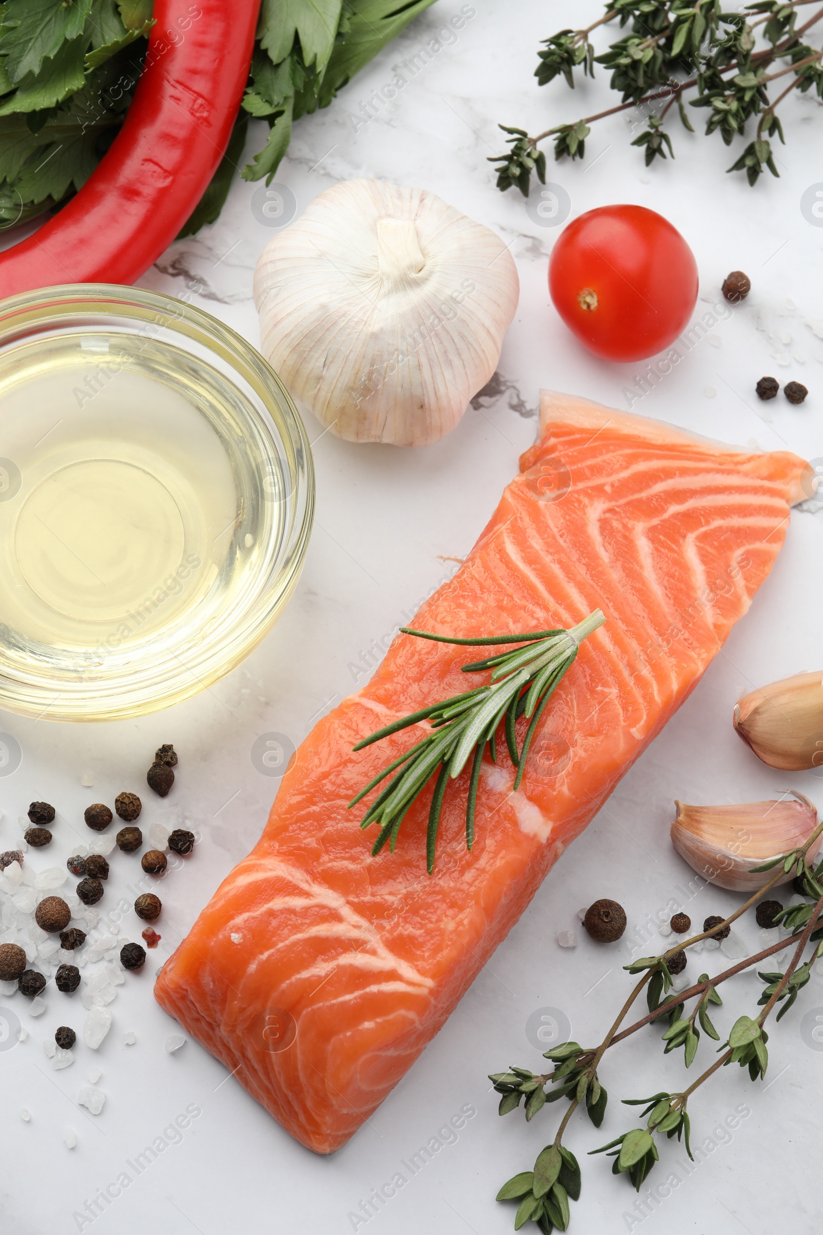 Photo of Fresh salmon and ingredients for marinade on white marble table, flat lay