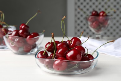 Photo of Sweet red cherries in bowl on white wooden table
