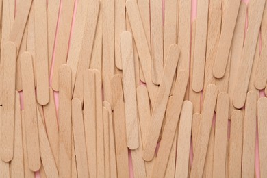 Photo of Disposable wooden waxing spatulas as background, closeup view