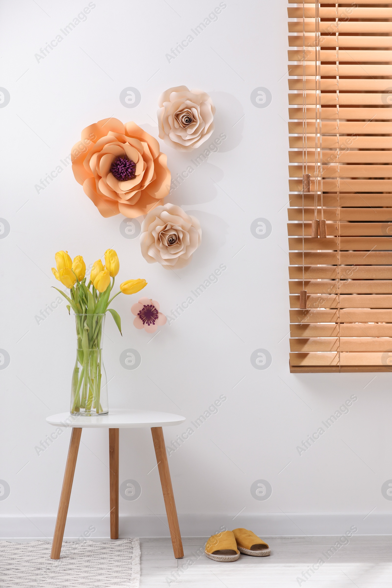 Photo of Stylish room interior with floral decor and yellow tulips