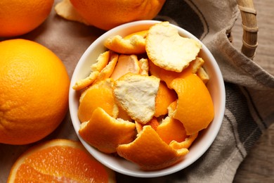 Photo of Orange peels preparing for drying and fresh fruits on wooden table, top view