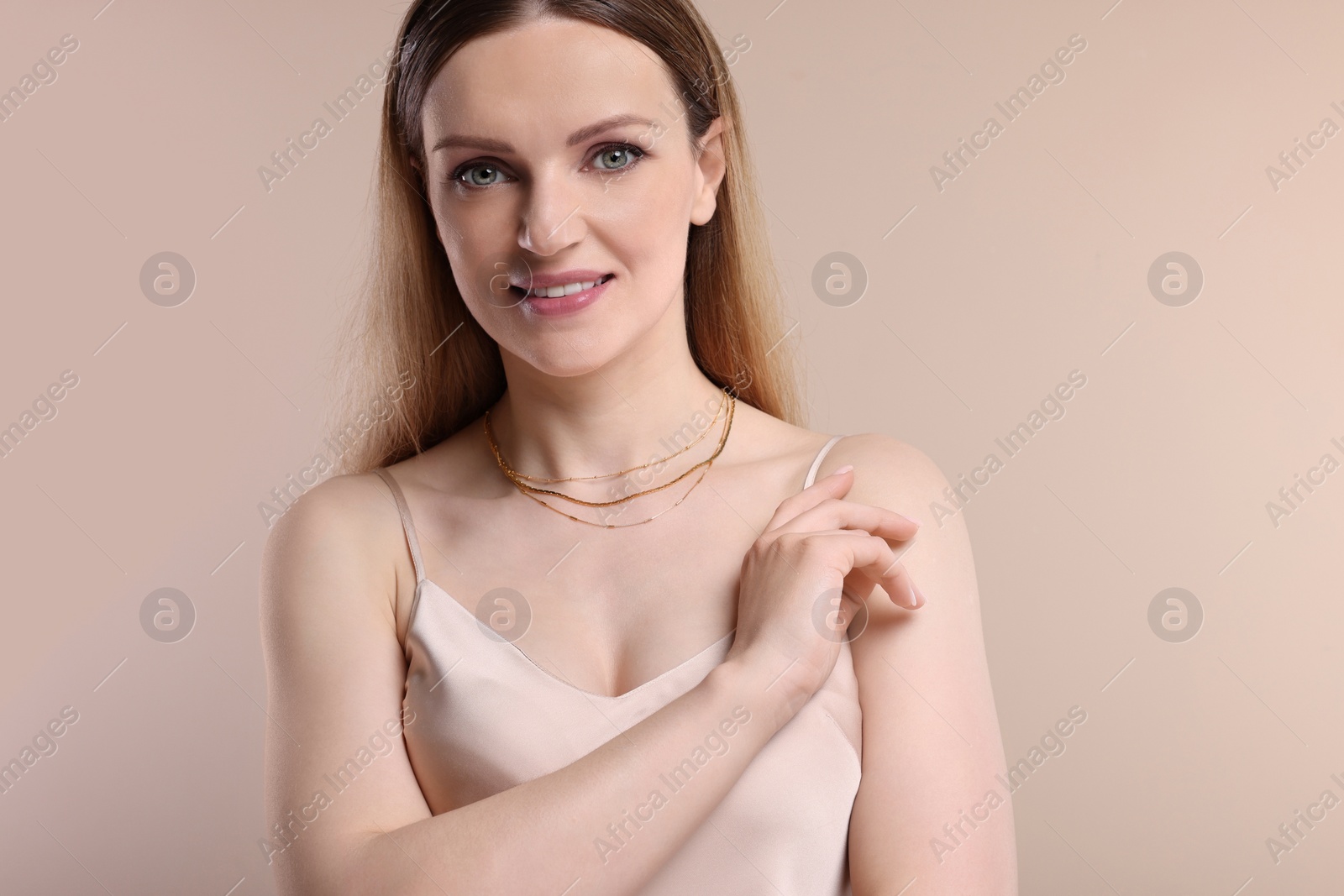 Photo of Beautiful woman with elegant necklace on beige background