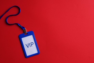 Plastic vip badge on red background, top view. Space for text