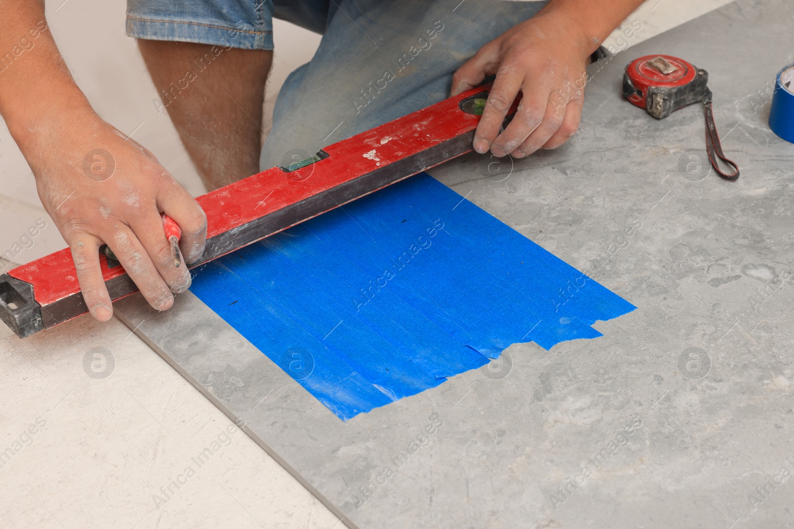 Photo of Worker making socket hole in tile indoors, closeup