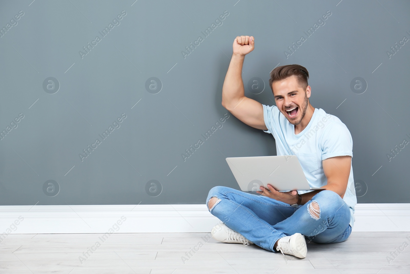 Photo of Emotional man with laptop near color wall