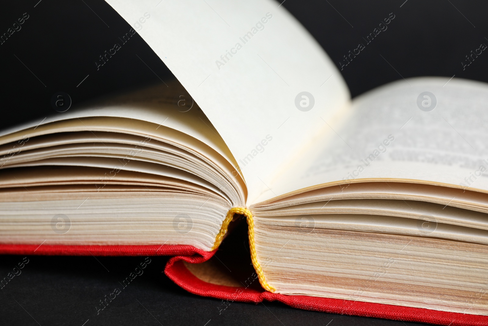 Photo of Closeup view of open book on black background