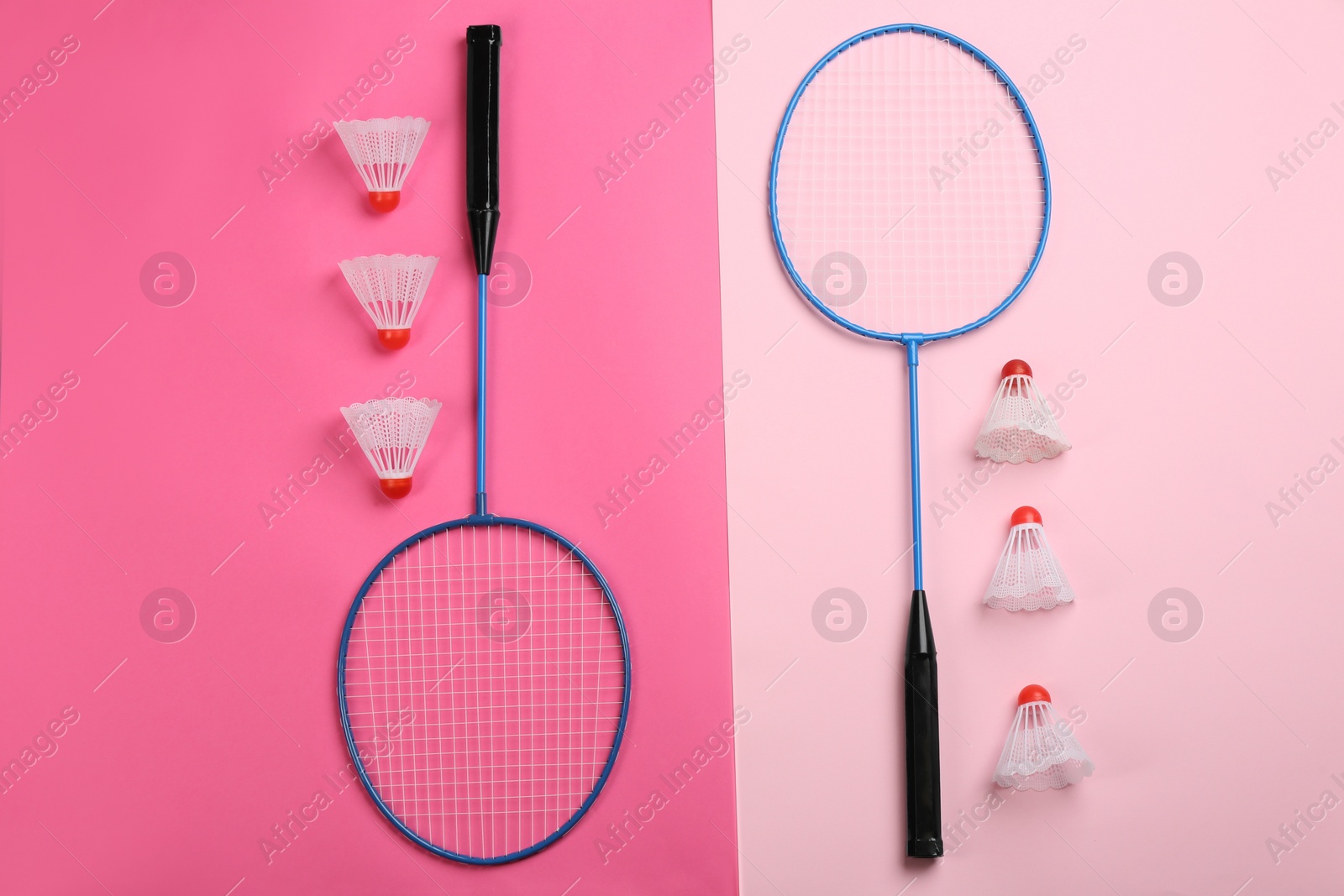 Photo of Rackets and shuttlecocks on color background, flat lay. Badminton equipment