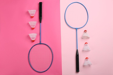 Photo of Rackets and shuttlecocks on color background, flat lay. Badminton equipment