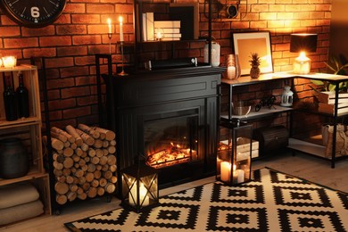 Photo of Beautiful fireplace and different decor in living room at night. Interior design