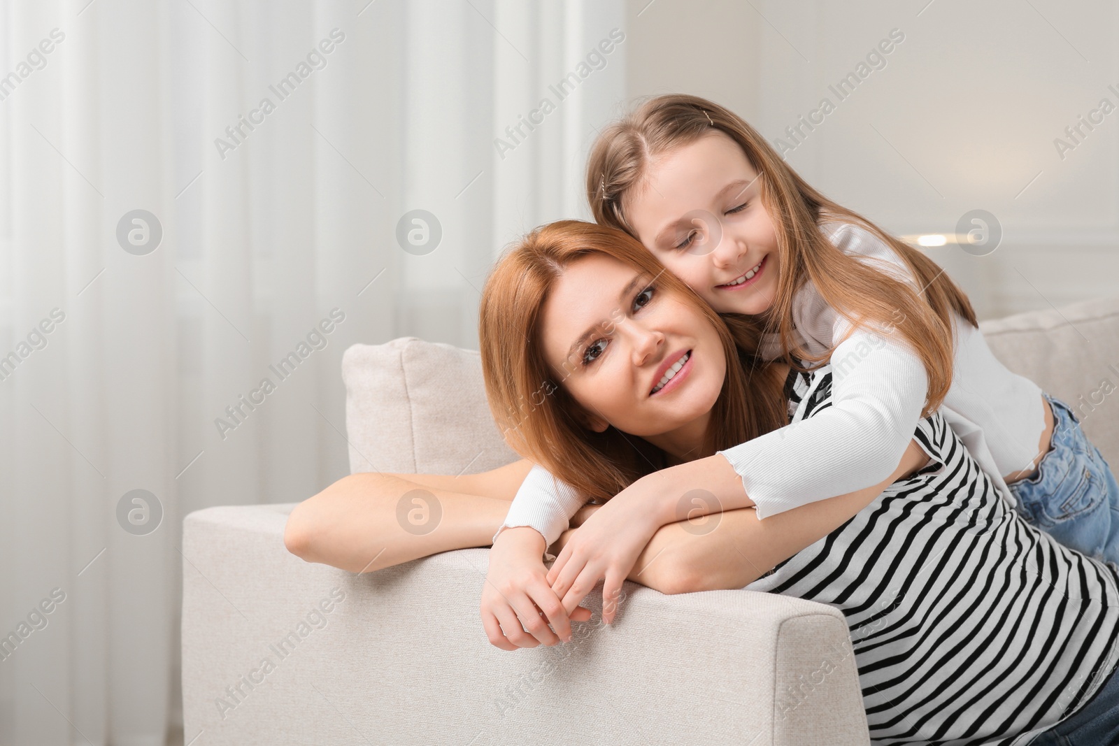Photo of Mother and her cute daughter spending time together at home. Space for text