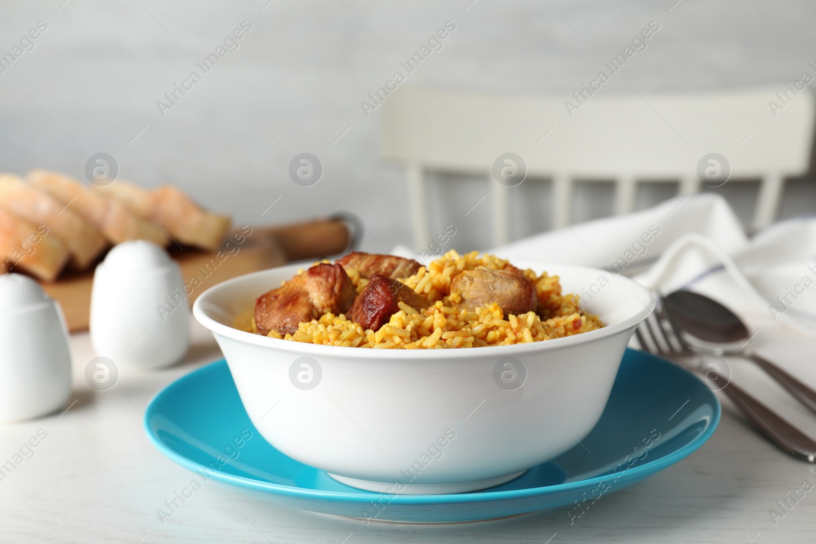 Photo of Bowl of tasty rice pilaf with meat served on table