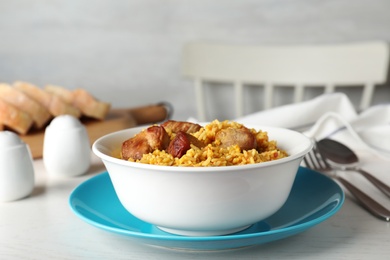 Bowl of tasty rice pilaf with meat served on table