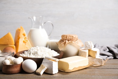 Photo of Different delicious dairy products on wooden table