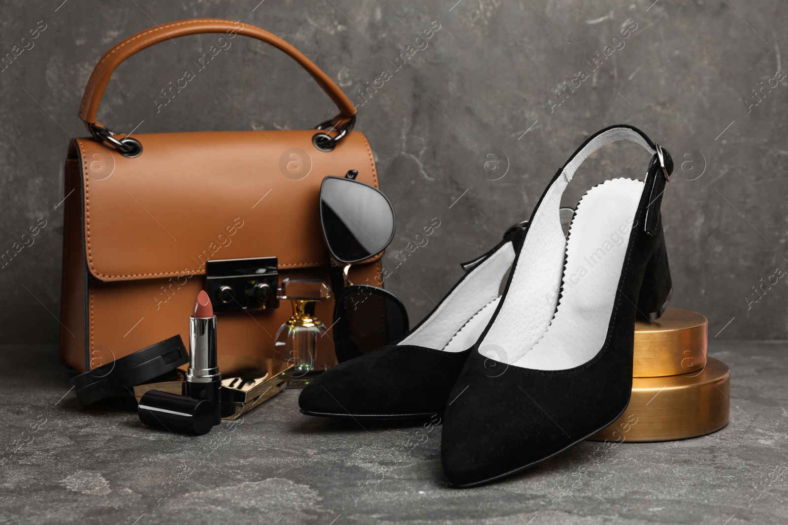 Photo of Composition with stylish black female shoes on grey stone table
