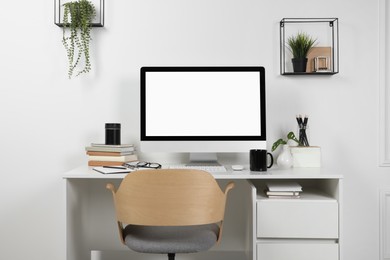 Cozy workspace with computer and stationery on wooden desk at home