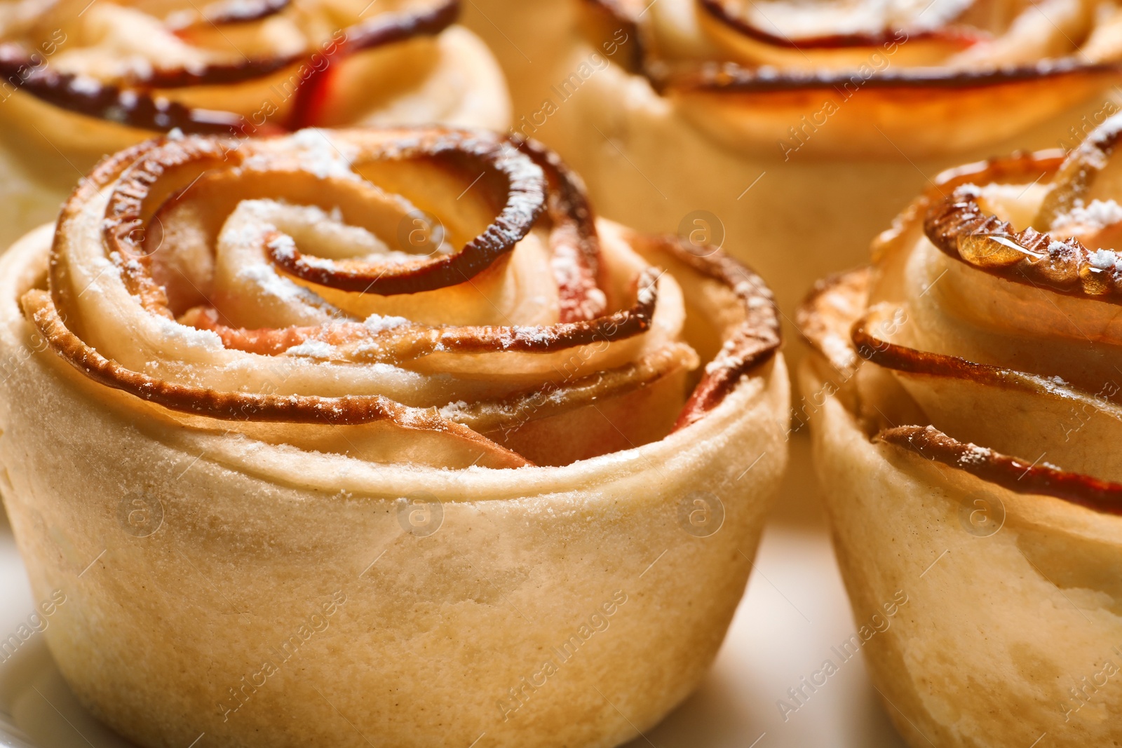 Photo of Freshly baked apple roses on plate, closeup. Beautiful dessert