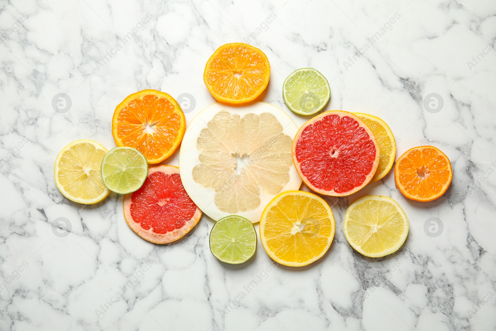 Photo of Different citrus fruits on marble background, top view