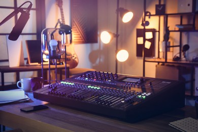Photo of Professional mixing console on table in radio studio
