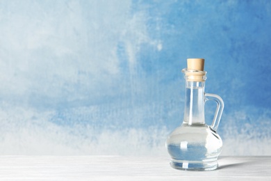 Photo of Glass jug with vinegar and space for text on color background