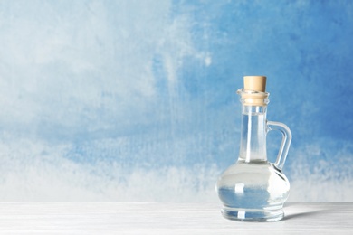 Glass jug with vinegar and space for text on color background