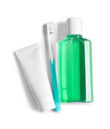 Fresh mouthwash in bottle, toothpaste and toothbrush isolated on white, top view