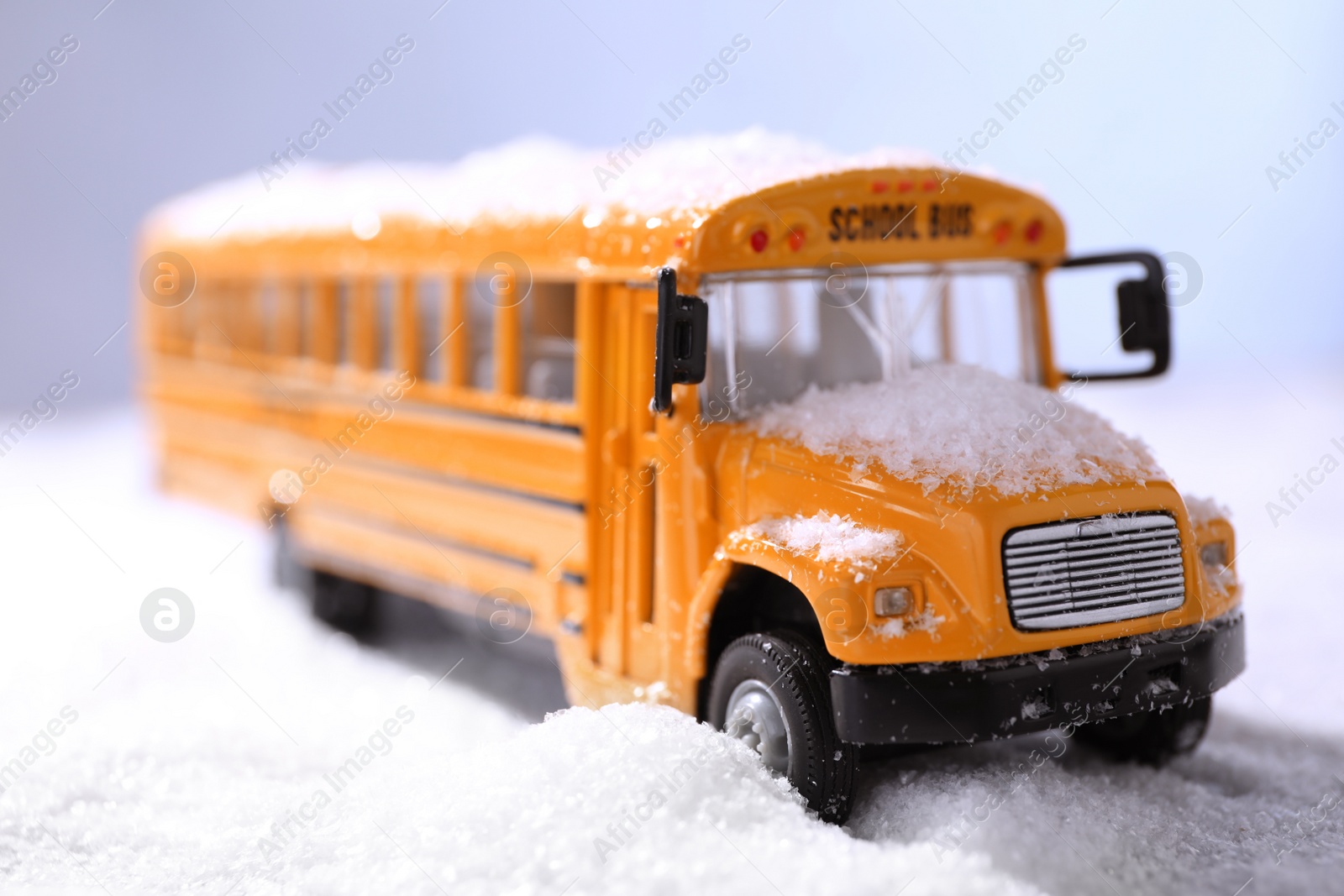 Photo of Yellow school bus on snowy road, closeup. Transport for students