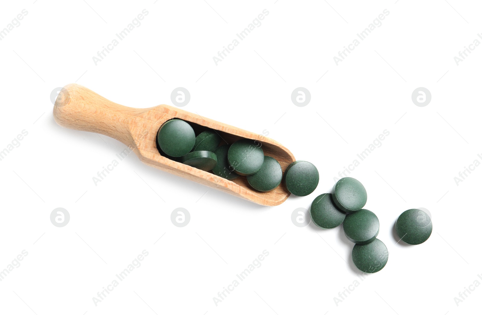 Photo of Scoop with spirulina tablets on white background, top view