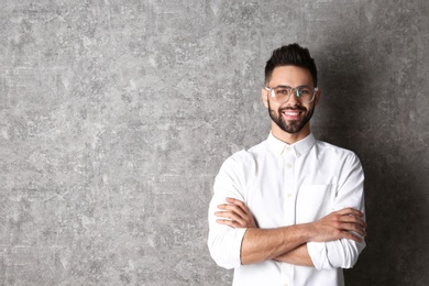 Portrait of handsome smiling man in glasses on grey background. Space for text