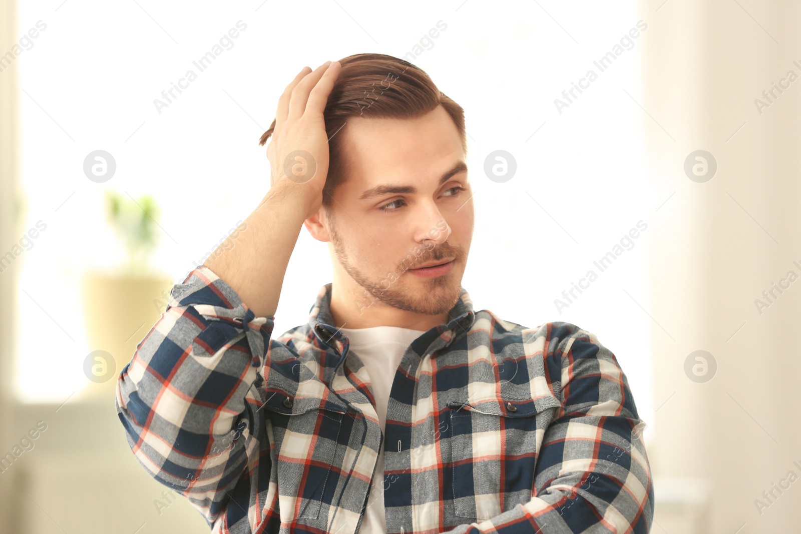 Photo of Portrait of young man with beautiful hair indoors