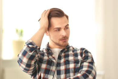 Portrait of young man with beautiful hair indoors