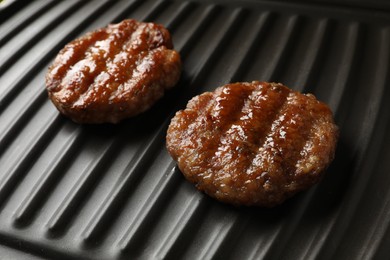 Delicious hamburger patties on electric grill, closeup