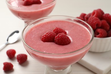 Photo of Delicious raspberry mousse on white wooden table
