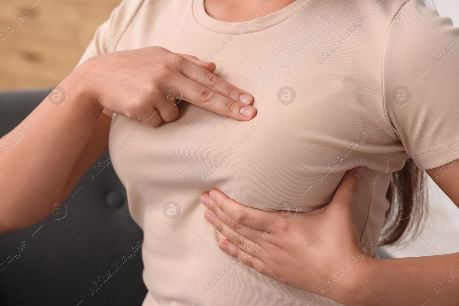 Photo of Woman doing breast self-examination at home, closeup