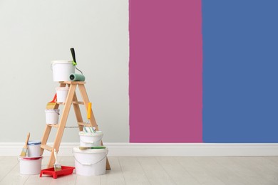 Decorator's kit of tools and paints near wall indoors