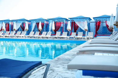 Photo of Outdoor swimming pool and sunbeds at resort on sunny day