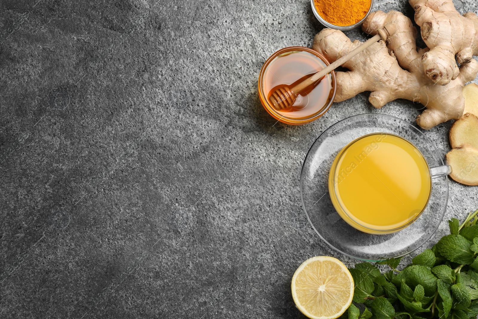 Photo of Flat lay composition with immunity boosting drink and ingredients on grey table. Space for text