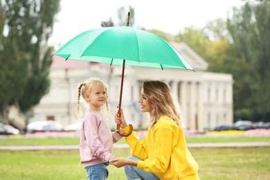 Photo of Happy mother and daughter with umbrella in park
