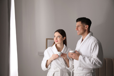 Happy couple in bathrobes with coffee at home