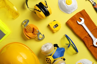 Photo of Flat lay composition with safety equipment on color background