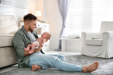 Photo of Father with his newborn son at home