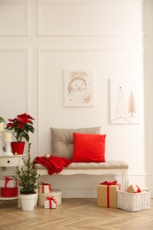 Christmas themed pictures in bright room with festive decorations. Interior design