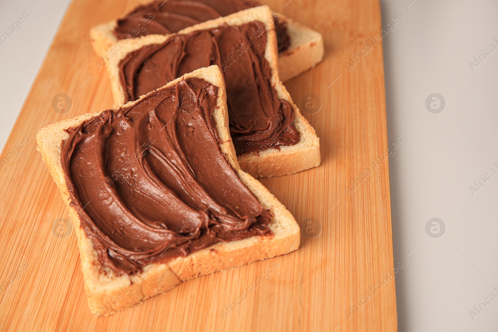 Photo of Tasty toasts with chocolate paste on beige background, closeup. Space for text