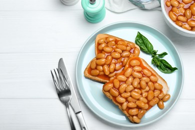 Photo of Toasts with delicious canned beans on white wooden table, flat lay