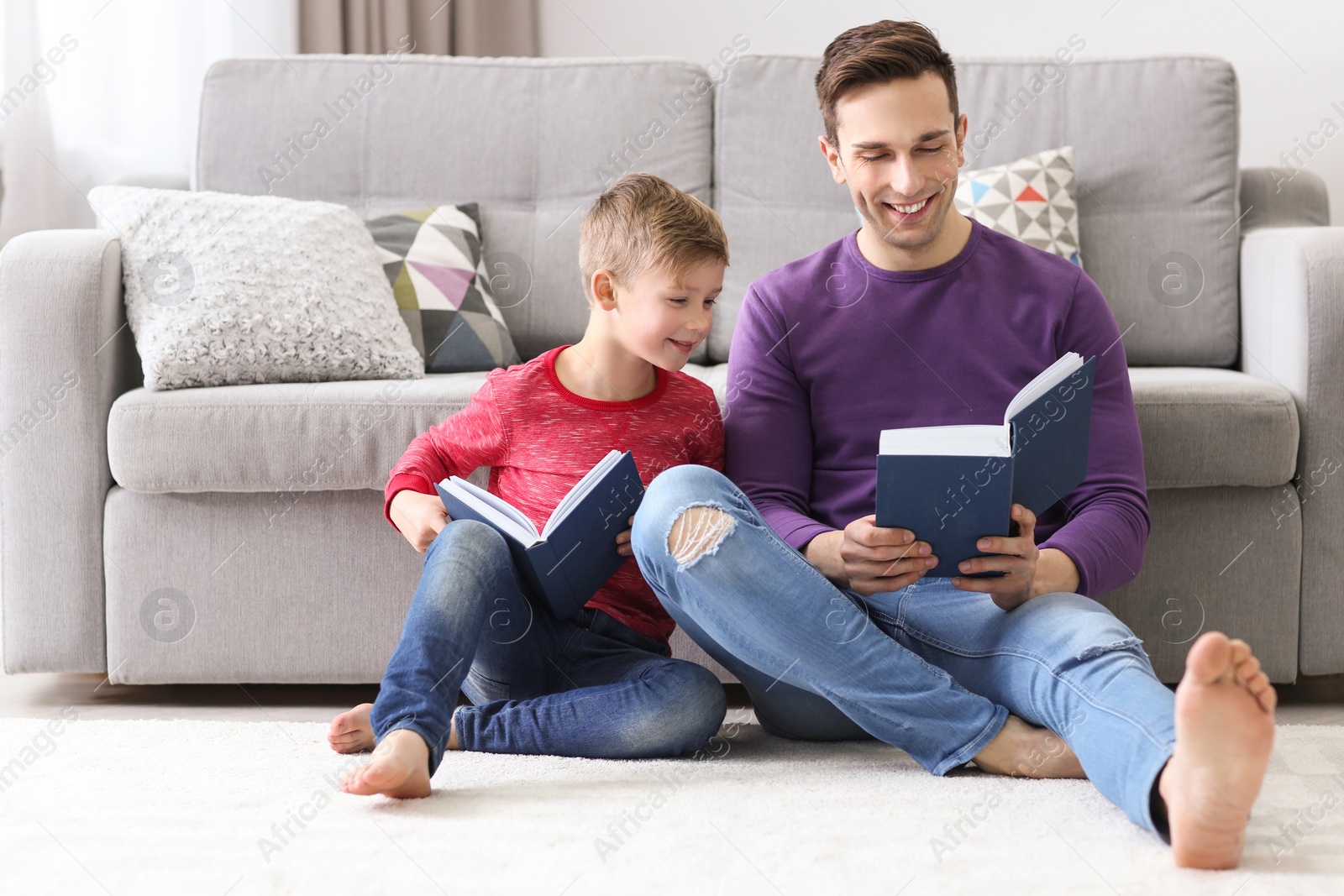 Photo of Dad and his son reading book at home